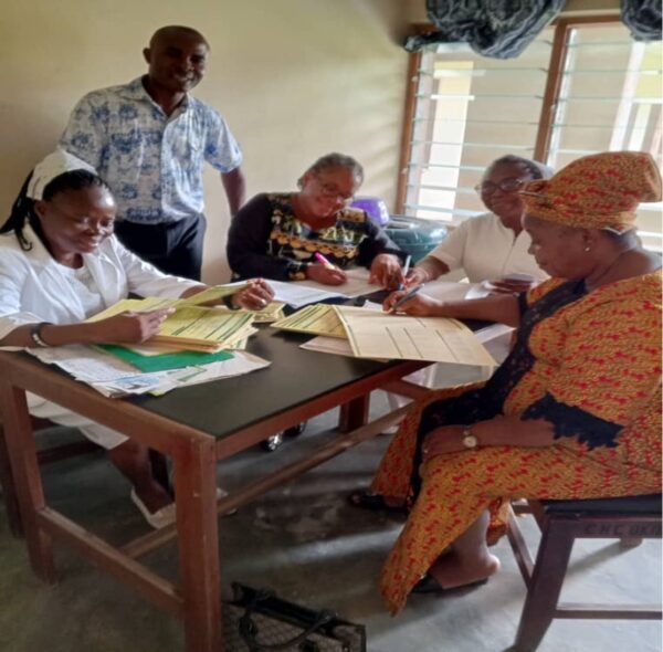 A group of five people sit around a desk.